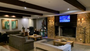 Un salon moderne avec une cheminée, des sièges confortables et un sapin de Noël.