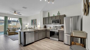 Enjoy cooking in this kitchen with a dishwasher, stainless steel refrigerator, and double oven, plus a large window overlooking the outdoor area.