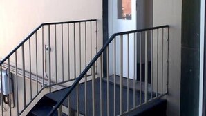 Una escalera con barandillas de metal que conduce a un espacio interior.