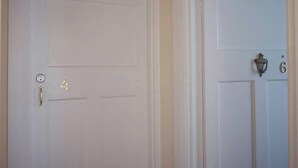 Puerta blanca con picaporte de latón y una placa con el número 4.