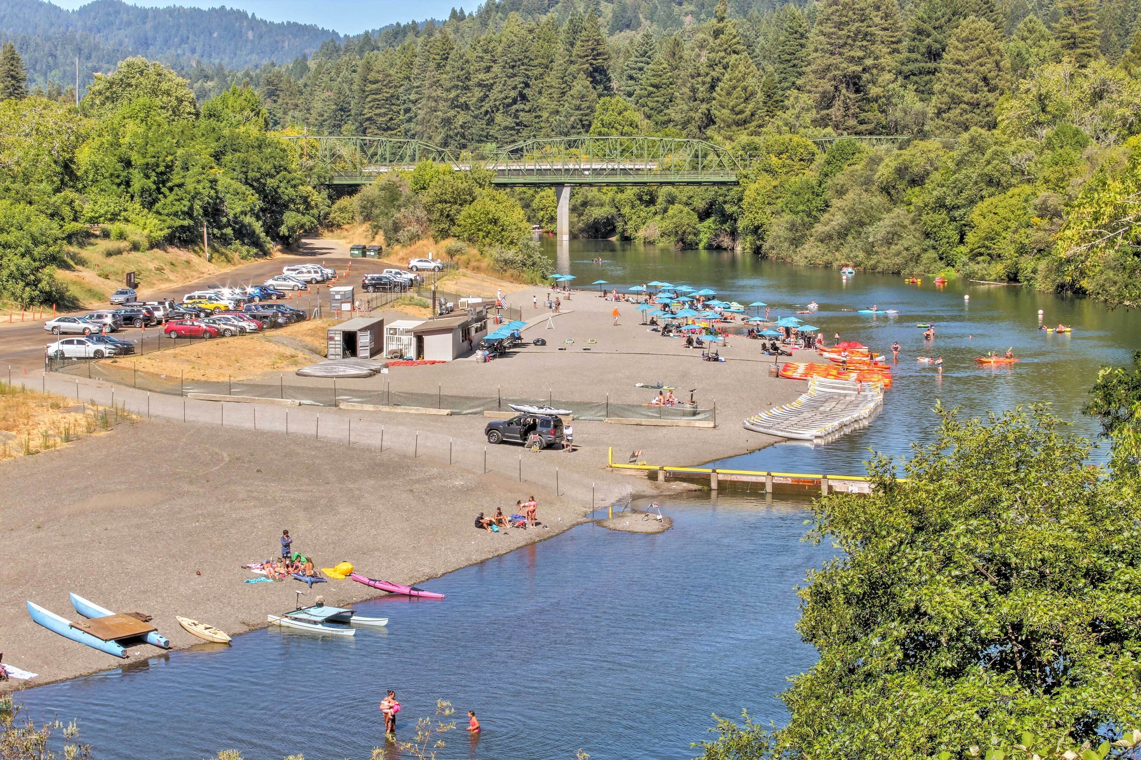 Un espace de stationnement au bord de la rivière, avec des bateaux, un pont et un quai.
