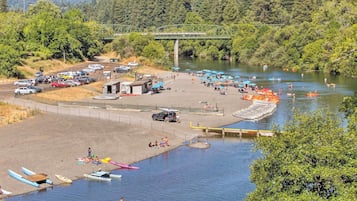 Un espace de stationnement au bord de la rivière, avec des bateaux, un pont et un quai.