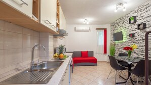 A compact kitchen with a sink, stove, and a dining area with a table and chairs. - Charming Duplex in the Heart of the Old Town (Split)