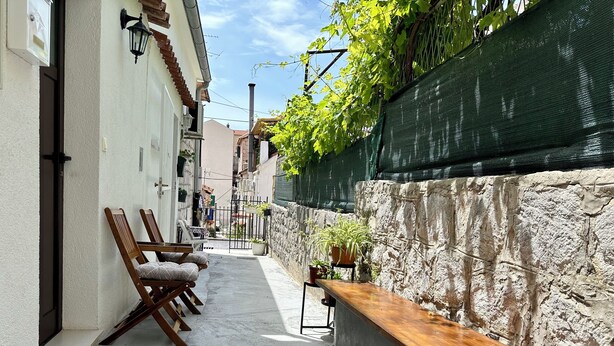 A narrow alleyway with a bench and chairs, a stone wall, and a metal gate. - Charming Duplex in the Heart of the Old Town (Split)
