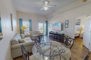 A spacious living area with a sofa set, a glass-top coffee table, and a TV. - Across from Beach, Heated Pool, with Marina View from Private Balcony. Great Location! (Madeira Beach)