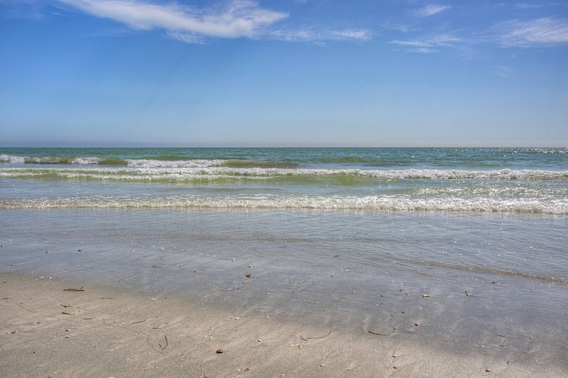 A beach with clear skies and gentle waves.