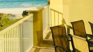 Ein Balkon mit Blick auf das Meer und den Strand, ausgestattet mit einer Brüstung und zwei Stühlen.