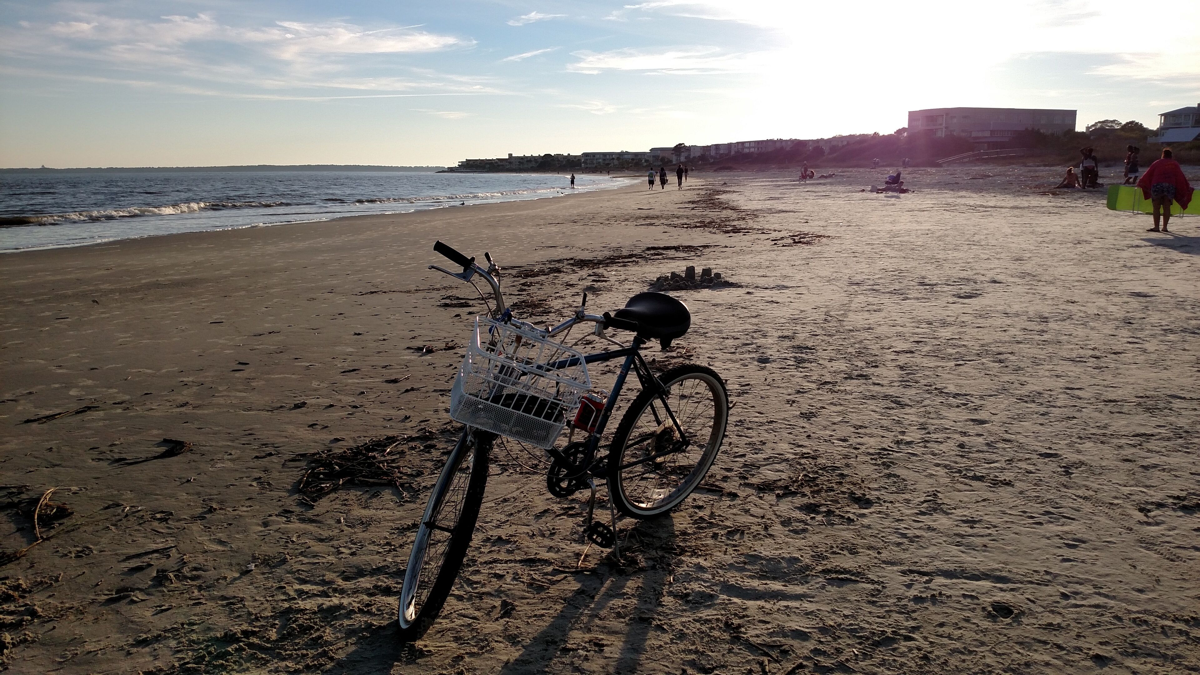 Ein Fahrrad steht auf einem sandigen Strand, im Hintergrund das Meer.