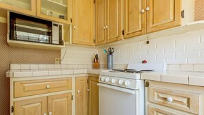 Una cocina con armarios de madera, una estufa blanca y un microondas.
