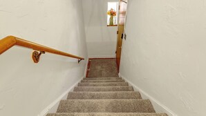 Una escalera con barandilla de madera que lleva a una plataforma.