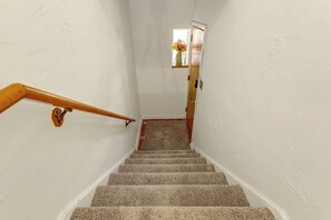 A staircase with a wooden handrail leading to a landing.