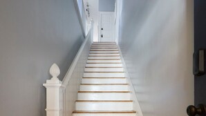 A staircase with white railings and wooden steps leading to a door. - Downtown Savannah Oasis 6 beds 3 baths (Savannah)