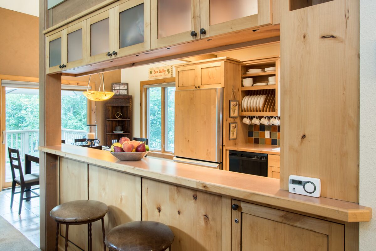 A kitchen with wooden cabinets, a fruit bowl, and a coffee machine.