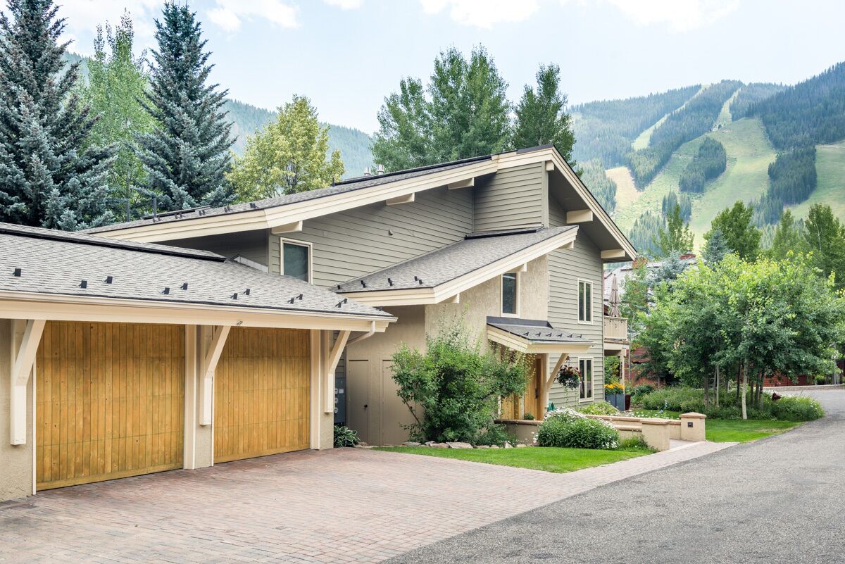 Une maison moderne à deux étages, dotée d’un garage, d’une allée couverte et d’une pelouse bien entretenue.