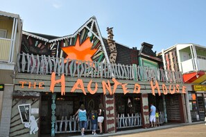 A building with a sign reading "The Haunted House". - Cute, casual 2-bedroom condo with free WiFi and a partial ocean view located midtown and less than a block to the beach! (Ocean City)