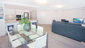 A modern apartment with a dining area, kitchen, and living room. - 2 Bedroom Apartment with pool and reverse Air conditioning (Mooloolaba)