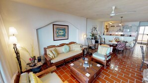 A living room with a sofa, armchairs, a coffee table, and a dining area with chairs and a table. - Bienvenido Amigo! In the heart of Amapas  2BD Condo for rent in Old Town, Puerto (Puerto Vallarta)