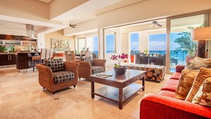 A spacious living area with a kitchen, dining area, and a balcony with a view.