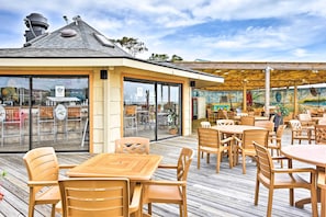 Enjoy meals under a covered pergola with views of the interior from the large window.