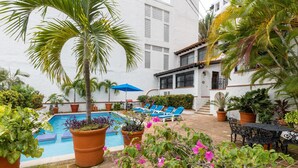A pool area with lounge chairs and potted plants. - Condo in Olas Altas 1  1BD Studio for rent in Old Town, Puerto vallarta (Puerto Vallarta)