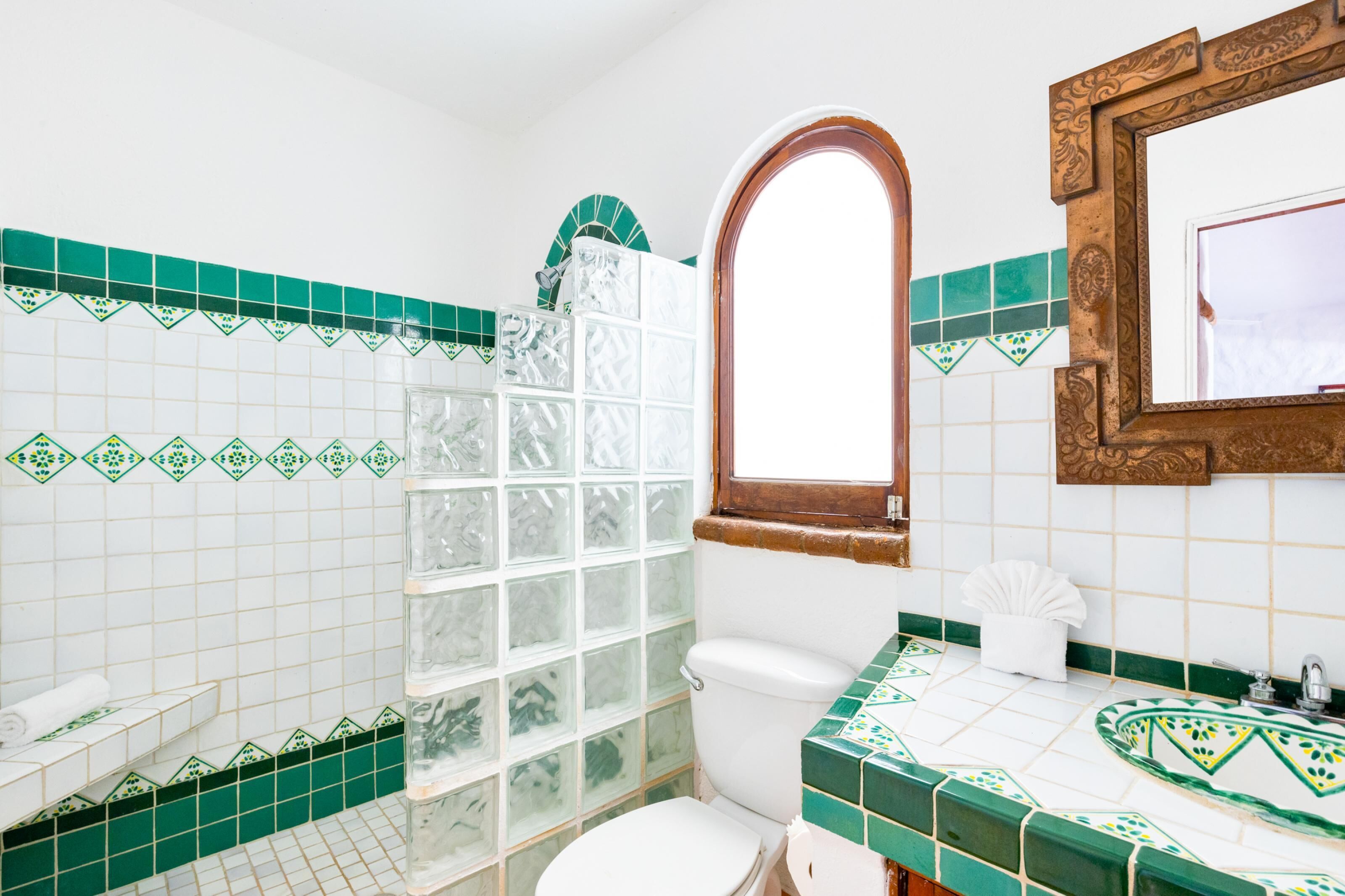 A bathroom with a toilet, a sink, and a shower area.