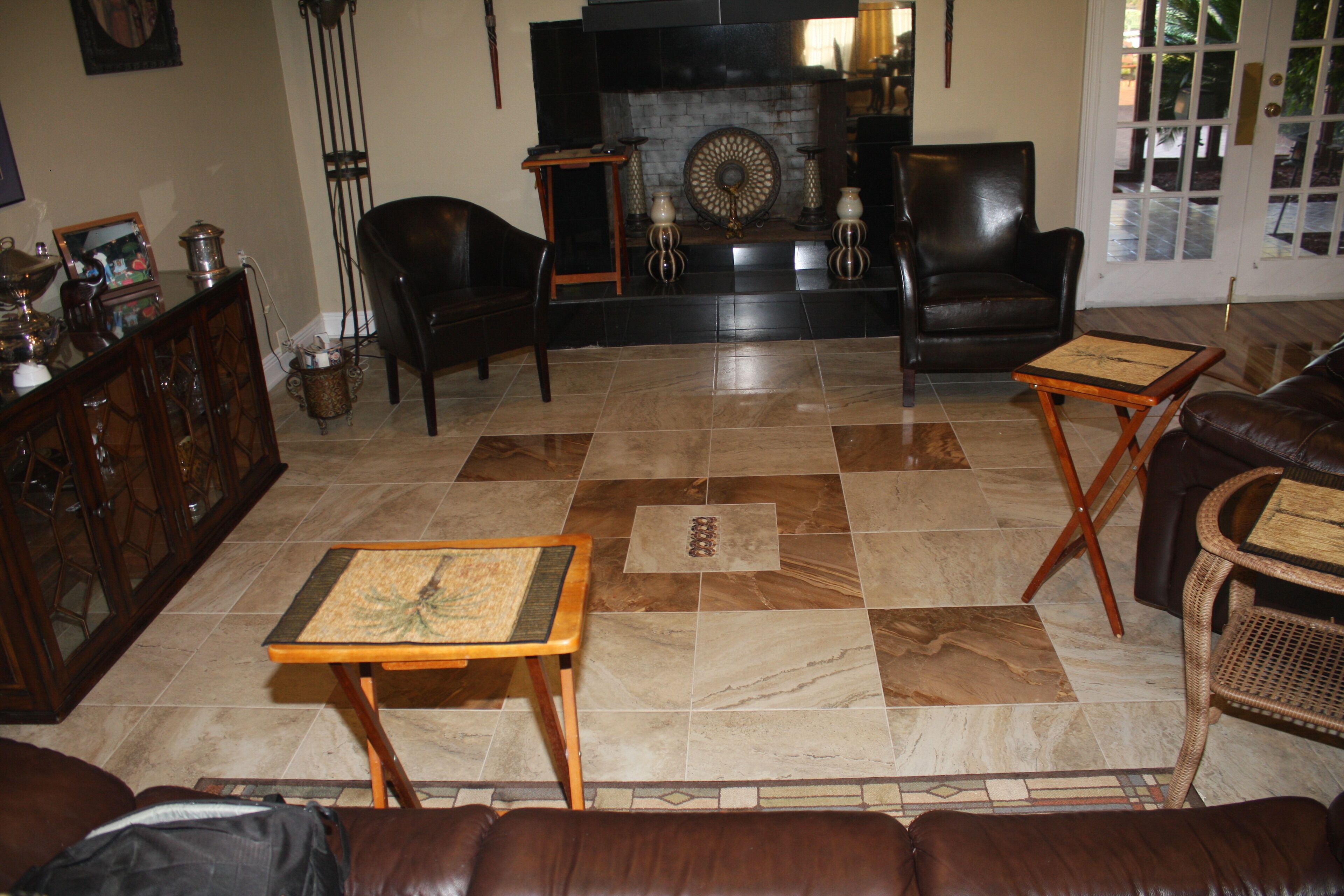 A living room with a fireplace, leather furniture, and a checkered floor.