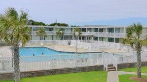 Ein Hotel mit Poolbereich, mehreren Balkonen und Bergblick.
