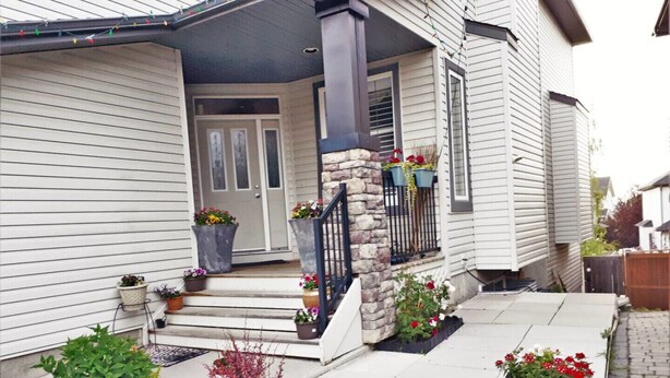 A house with a front porch, stone steps, and potted plants. - Bright, Welcoming Mountain Escape! Near Downtown! (Calgary)