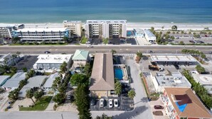 Ein Hotel an der Küste mit mehreren Stockwerken, einem Parkplatz und Blick auf den Strand und das Meer.