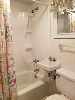Un baño con bañera, lavamanos e inodoro.