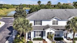 A two-story house with a grey roof, white walls, and dark shutters. - Lake View End Unit Town Home Closest to ALL of the Amenities at WINDSOR HILLS (Kissimmee)