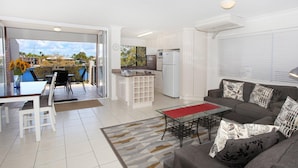 A modern apartment with a kitchen, dining area, and living room.