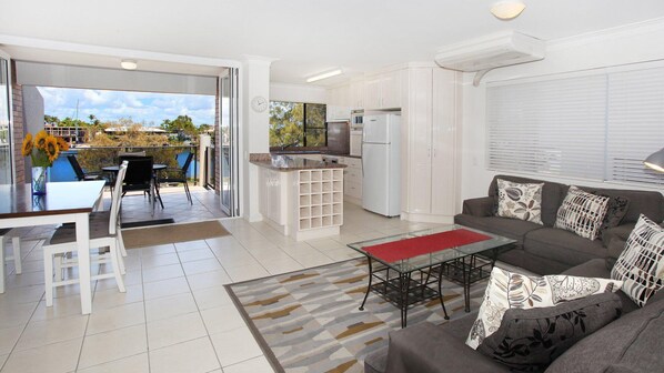A modern apartment with a kitchen, dining area, and living room.