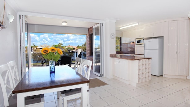 A modern kitchen with white cabinets, a built-in microwave, and a refrigerator.