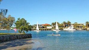 A marina with boats, a sandy beach, and a building with a red roof.