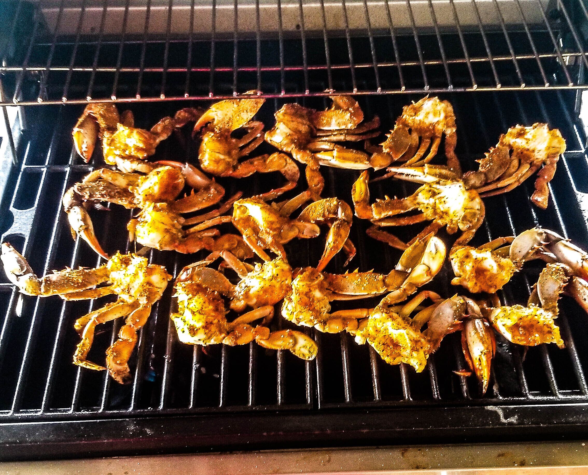 Crabs being grilled on a grill.