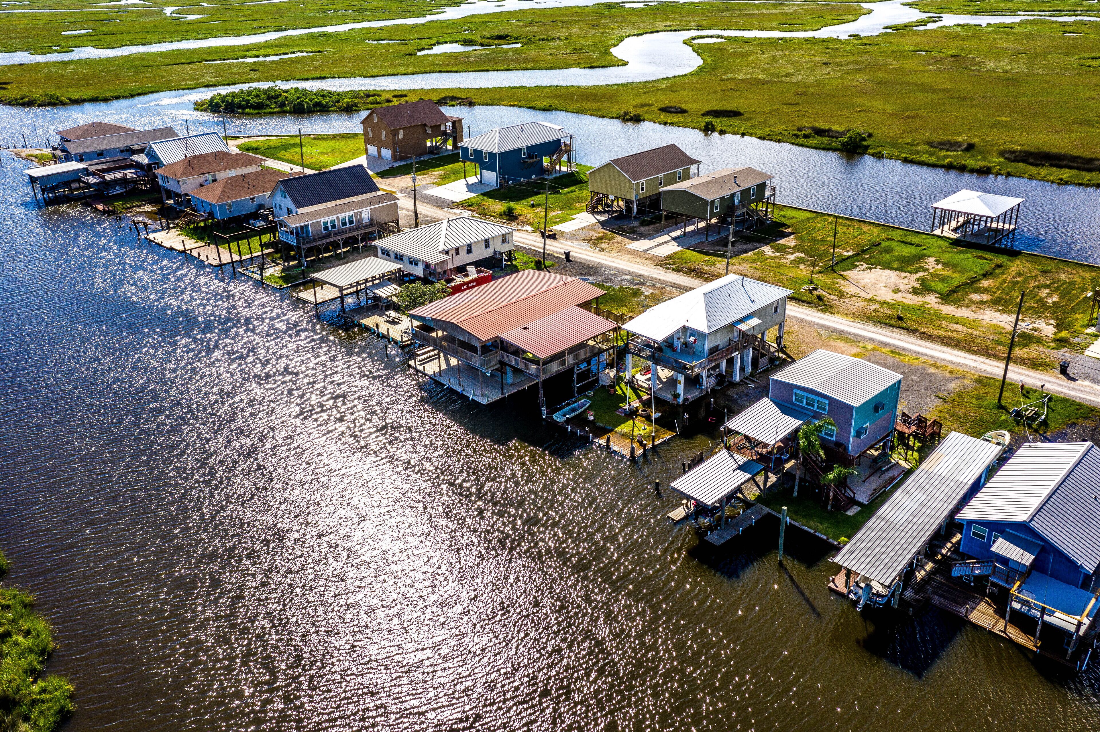 A waterfront property with multiple houses connected by docks, surrounded by water and greenery.