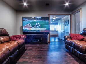 A living room with a large flat-screen TV on a stand, leather sofas, and a wooden entertainment center. - Fishing - Happy Jack (Port Sulphur) Louisiana (Port Sulphur)