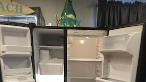 An open refrigerator with multiple shelves and a freezer compartment. -  Reel'em Inn - Adventures Start Here! (Port O'Connor)