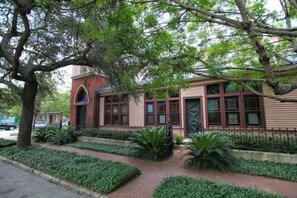 A building with a brick facade, large windows, and a gated entrance. - The Bell Tower Loft at Sanctuary Place (Savannah)