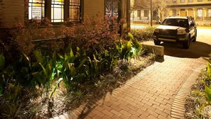 A building with a brick pathway leading to a car parked in front. - The Bell Tower Loft at Sanctuary Place (Savannah)