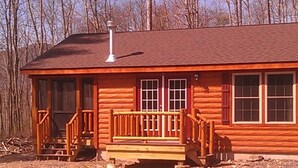 A log cabin with a porch, a chimney, and a view of the surrounding forest. - Log Cabin/screened porch, 9 Acres/ Mountain views (Woodstock)