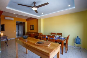 Un comedor con una mesa de madera, sillas y un ventilador de techo.