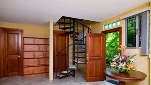 A room with a spiral staircase, wooden doors, and a round table with flowers. - Villa Bella Vista:  Views, Privacy & Beach Proximity, We Have It All Right Here (manuel antonio)