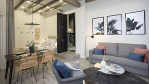 Una sala de estar moderna con un sofá, sillones, una mesa de centro y un comedor con mesa y sillas.