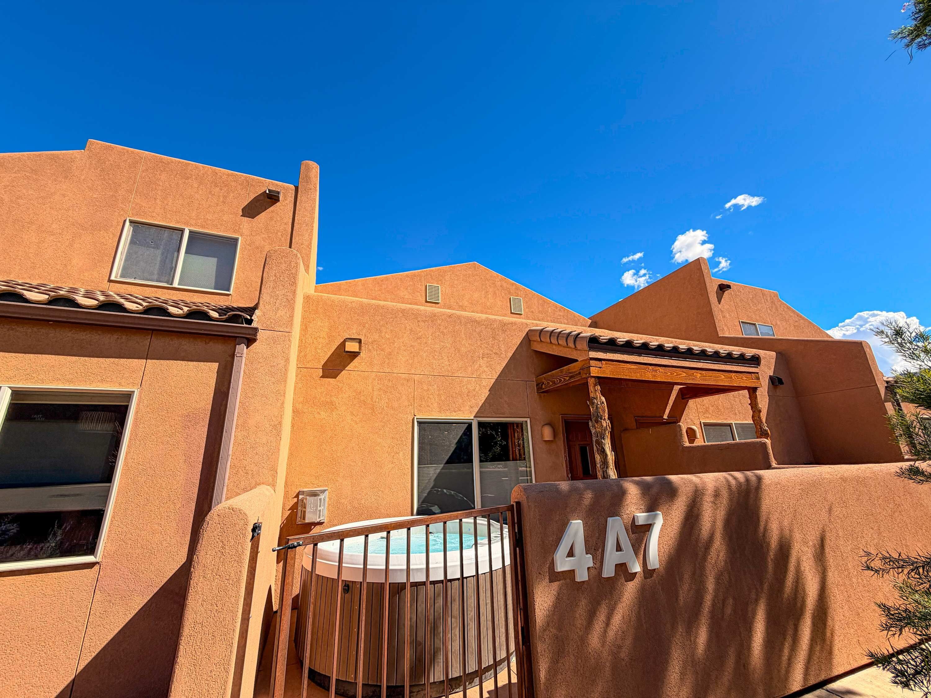 A building with a unique architectural style, a hot tub, and a clear blue sky.