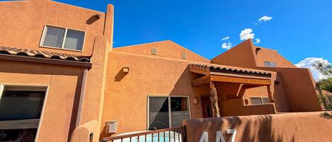 A building with a unique architectural style, a hot tub, and a clear blue sky.