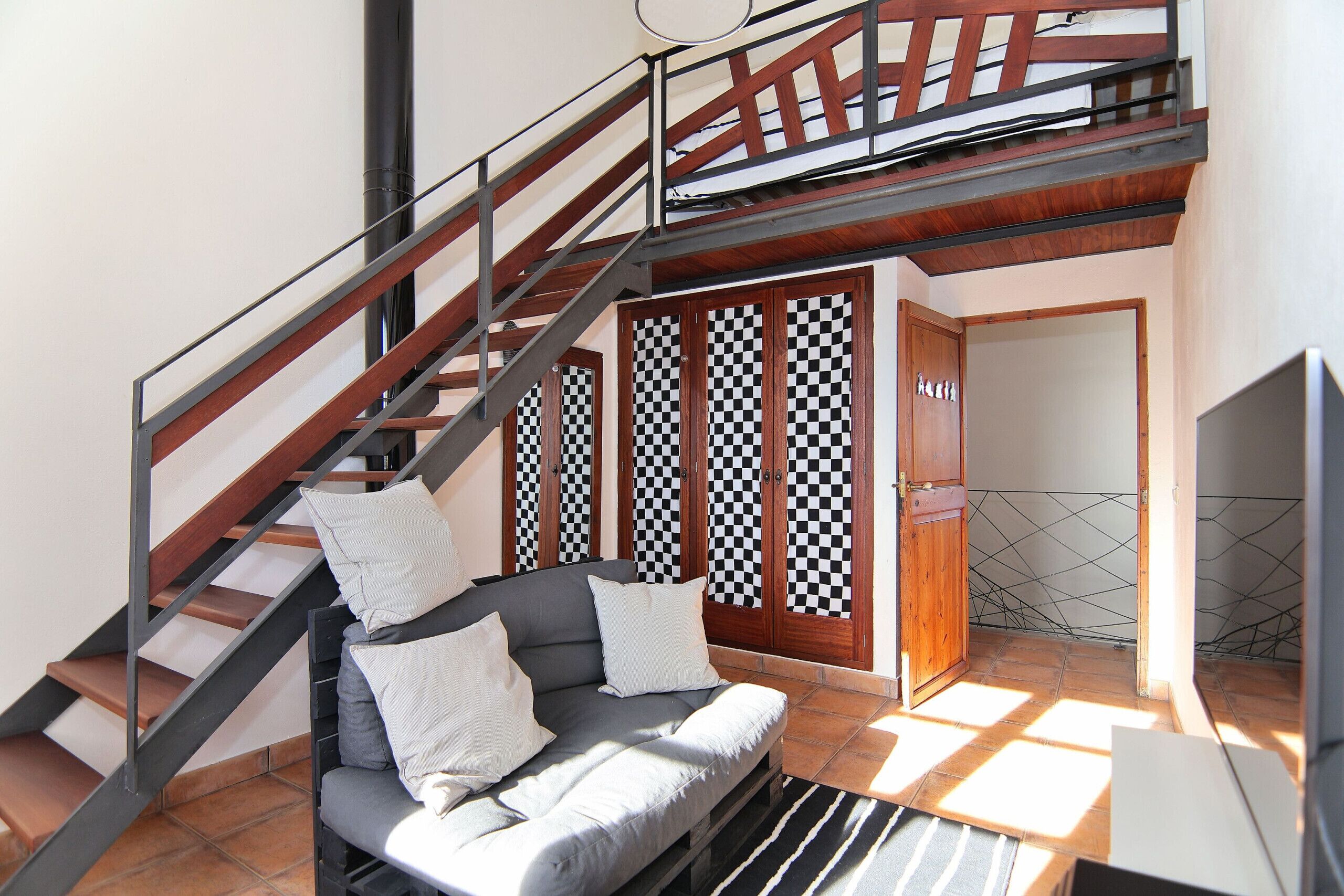 A staircase with a wooden handrail and metal balusters, leading to a second-floor landing.