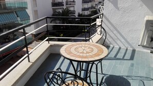 A rooftop terrace with a tiled table and chairs, a railing, and a view of the surrounding buildings. - Alexis II Zeus Salou 0632 (Salou)