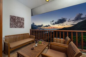 A balcony with wooden furniture, a view of a sunset over water, and a painting on the wall. - Spacious interior, 3 terraces with views, wifi [D] (Icod de los Vinos)